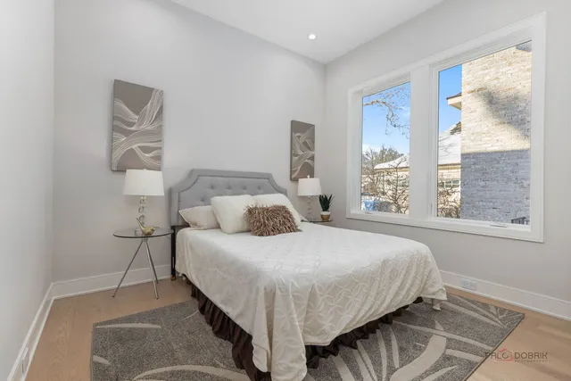 a bedroom with a bed and next to a window