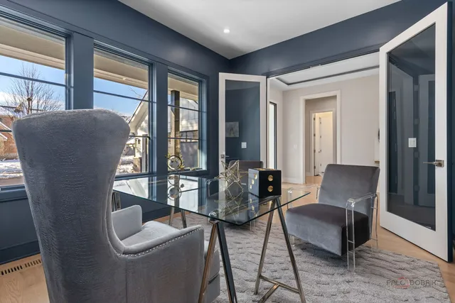 a living room with furniture and two large window