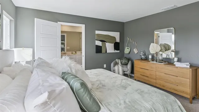a spacious bedroom with a bed and a dresser