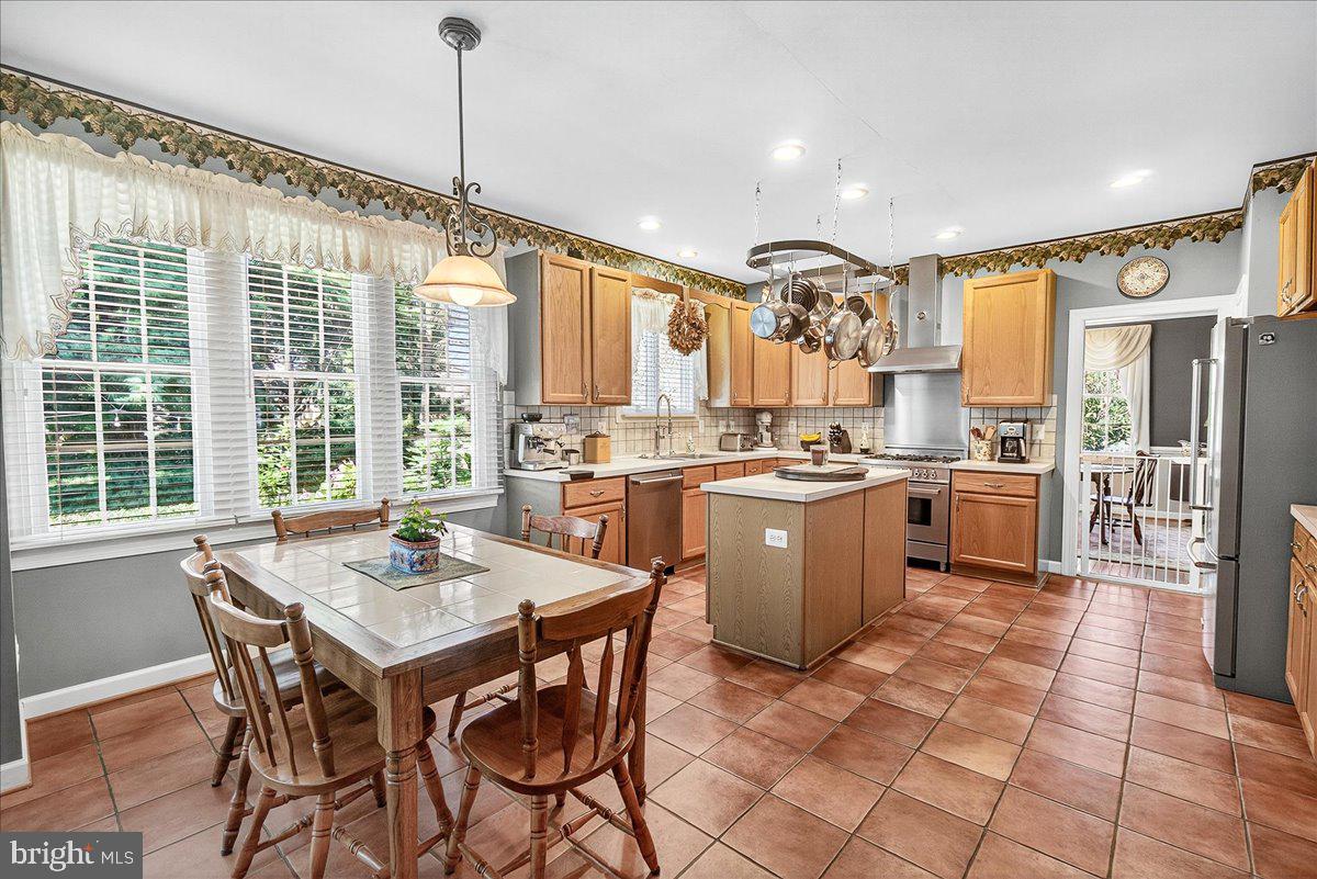 7010 Club House Circle New Market, MD 21774 - Photo 18 of 90 a open kitchen with stainless steel appliances granite countertop a stove a sink dishwasher a dining table and chairs with wooden floor