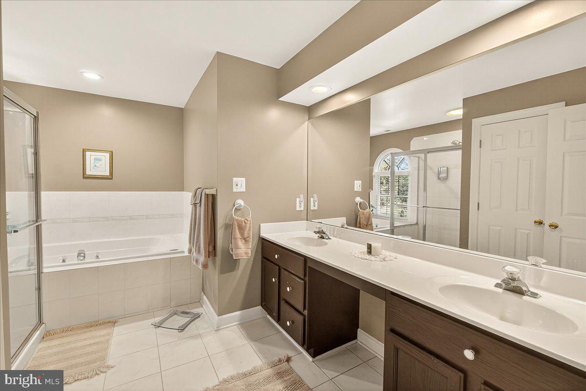 7010 Club House Circle New Market, MD 21774 - Photo 31 of 90 a spacious bathroom with a double vanity sink a large mirror and a bathtub
