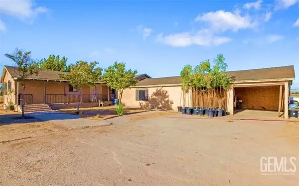 a view of a house with a patio and a yard