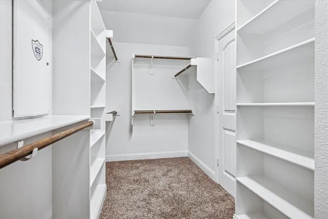 a view of walk in closet with empty racks