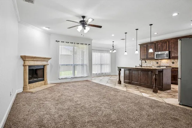 a view of kitchen with granite countertop cabinets and refrigerator