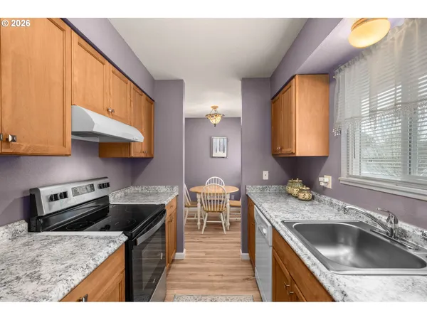 a kitchen that has a sink a stove counter top space and cabinets