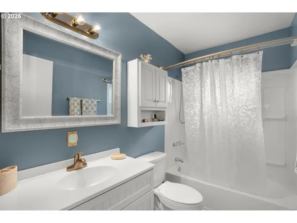 a bathroom with a sink a toilet a mirror and shower