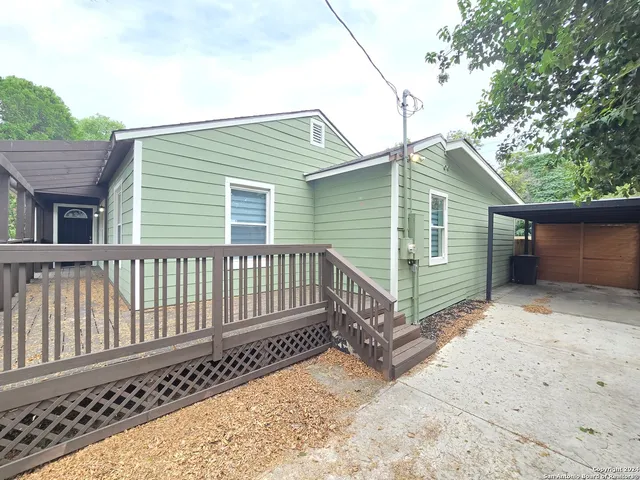 a view of a small house with wooden fence