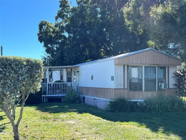 a view of a house with a yard deck and a patio