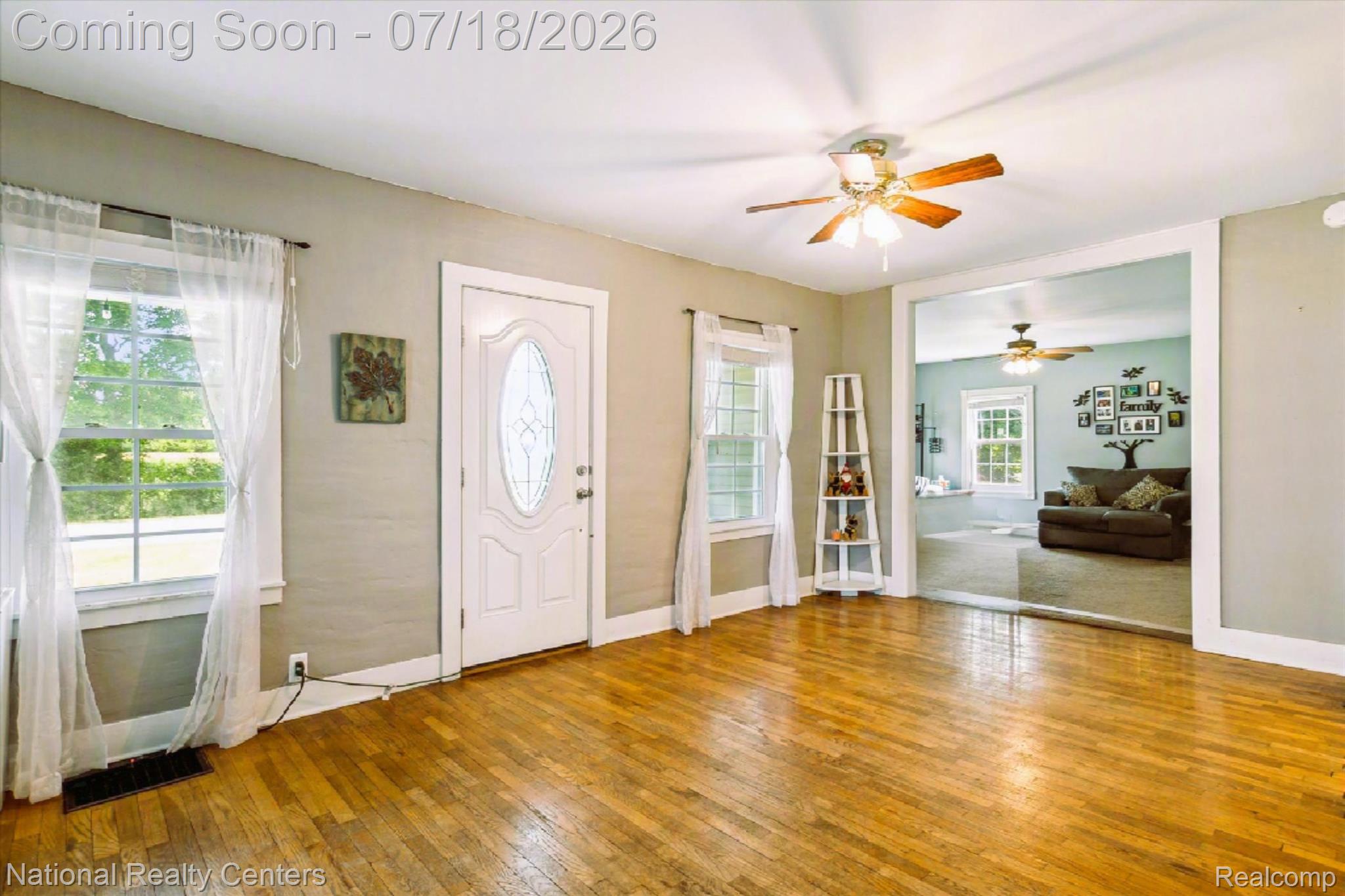 9589 Clinton Macon Road Tecumseh, MI 49286 - Photo 6 of 48 Hardwood flooring spans this room, featuring a white entry door with an oval leaded glass insert