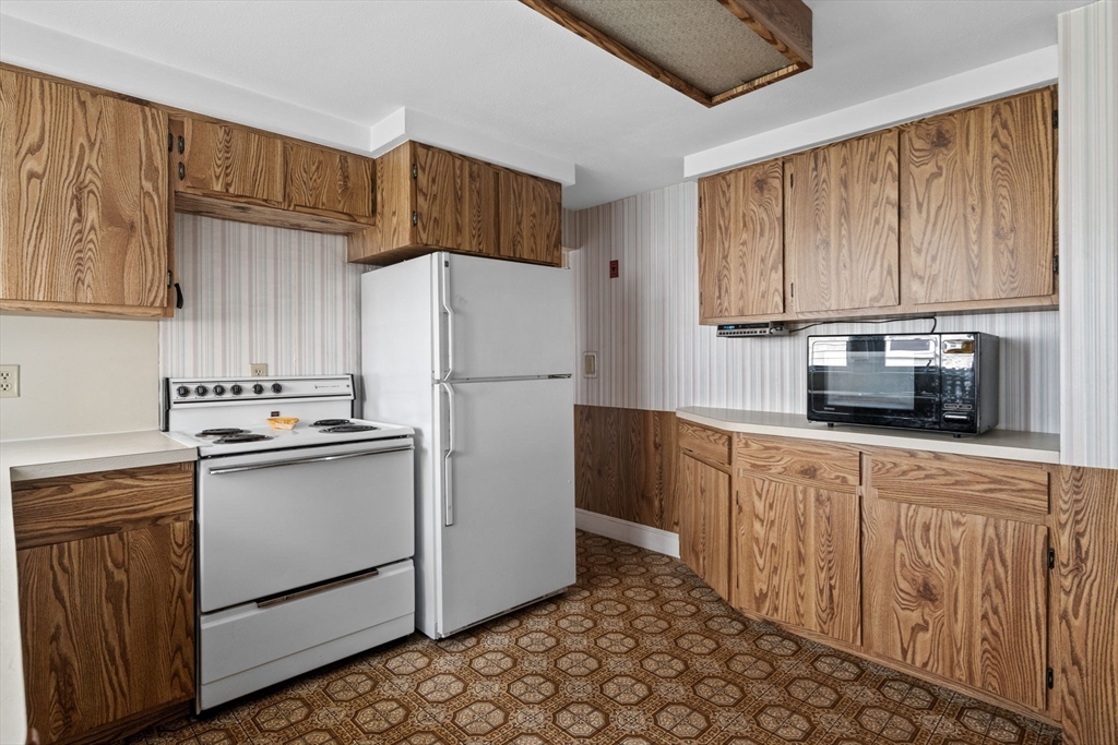10 Shepard Street Marblehead, MA 01945 - Photo 13 of 42 a kitchen with stainless steel appliances granite countertop a refrigerator sink and cabinets
