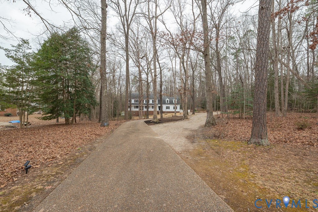 View of stamped concrete and gravel driveway