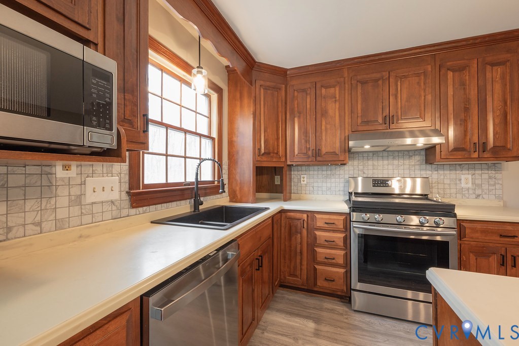 Kitchen with stainless steel appliances, brown cab