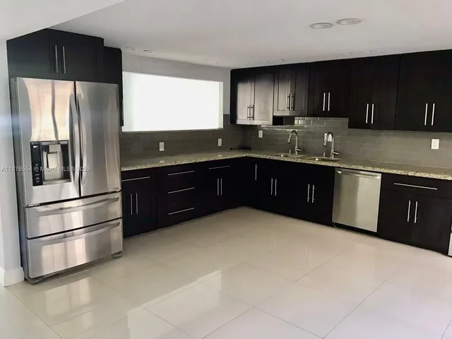 a kitchen with stainless steel appliances granite countertop a refrigerator and a sink
