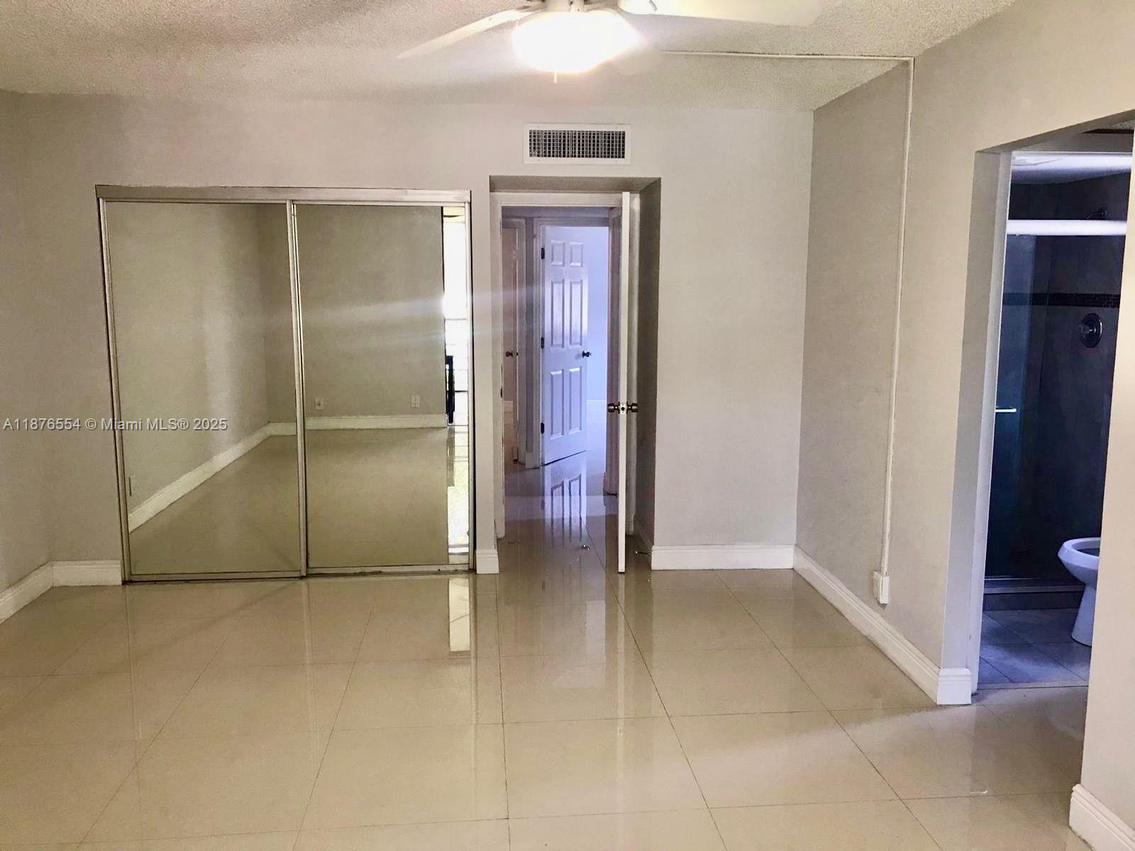 20381 Northeast 30th Avenue, Unit 2067 Aventura, FL 33180 - Photo 12 of 17 an empty room with closet and wooden floor