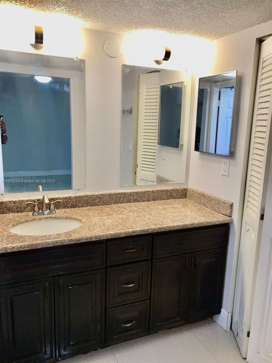 20381 Northeast 30th Avenue, Unit 2067 Aventura, FL 33180 - Photo 13 of 17 a bathroom with a granite countertop sink double and mirror