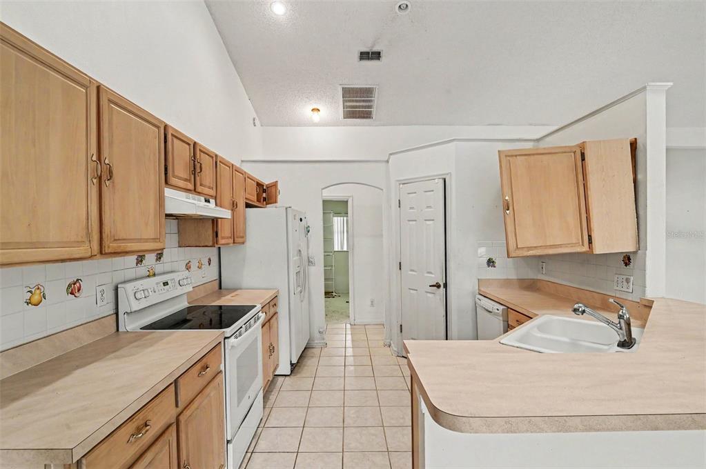 4716 Spaniel Street Orlando, FL 32818 - Photo 8 of 27 a large white kitchen with a granite countertop sink