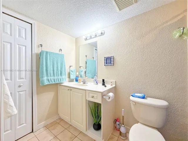 a bathroom with a granite countertop toilet sink and mirror