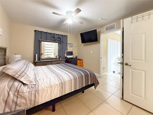 a bedroom with a bed flat screen tv and a large window