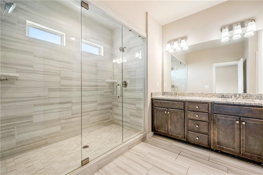 2747 Pearl Rdg Trace Buford, GA 30519 - Photo 19 of 41 a bathroom with a granite countertop sink mirror and shower