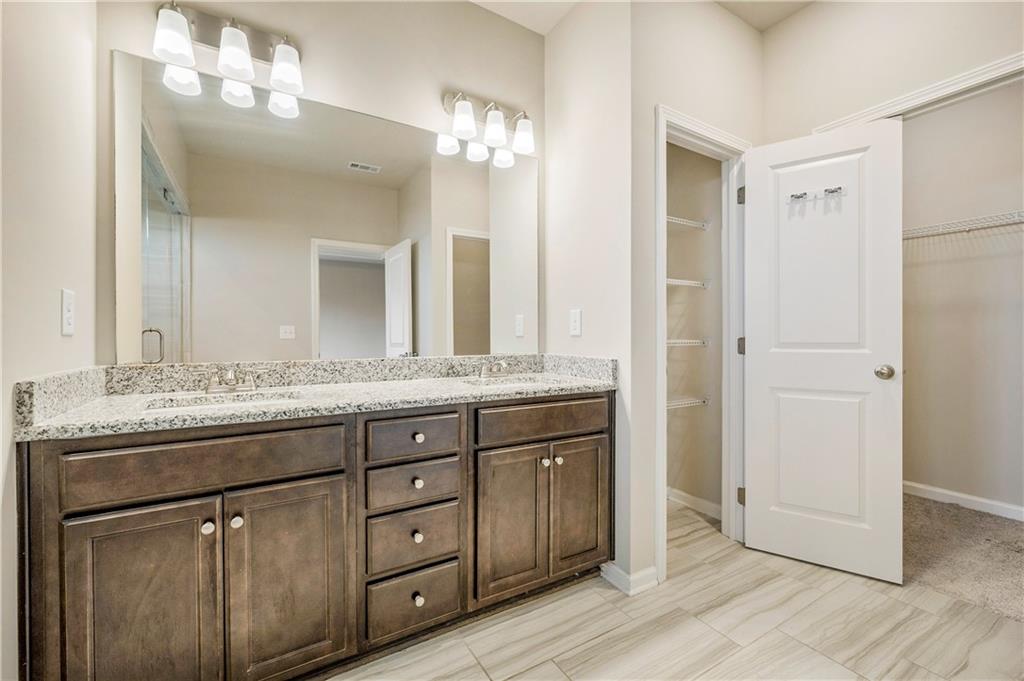 2747 Pearl Rdg Trace Buford, GA 30519 - Photo 22 of 41 a bathroom with a granite countertop sink a mirror and a shower