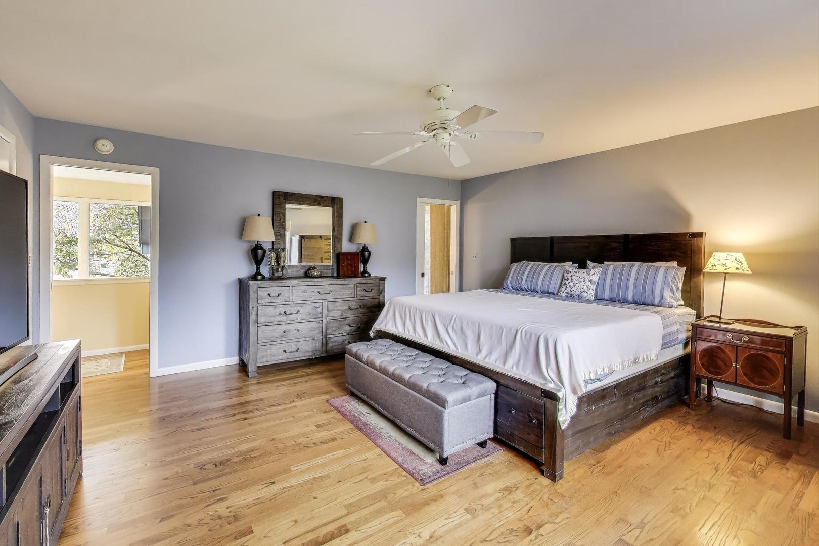 11515 Burr Oak Lane Burr Ridge, IL 60527 - Photo 23 of 73 a spacious bedroom with a bed and wooden floor