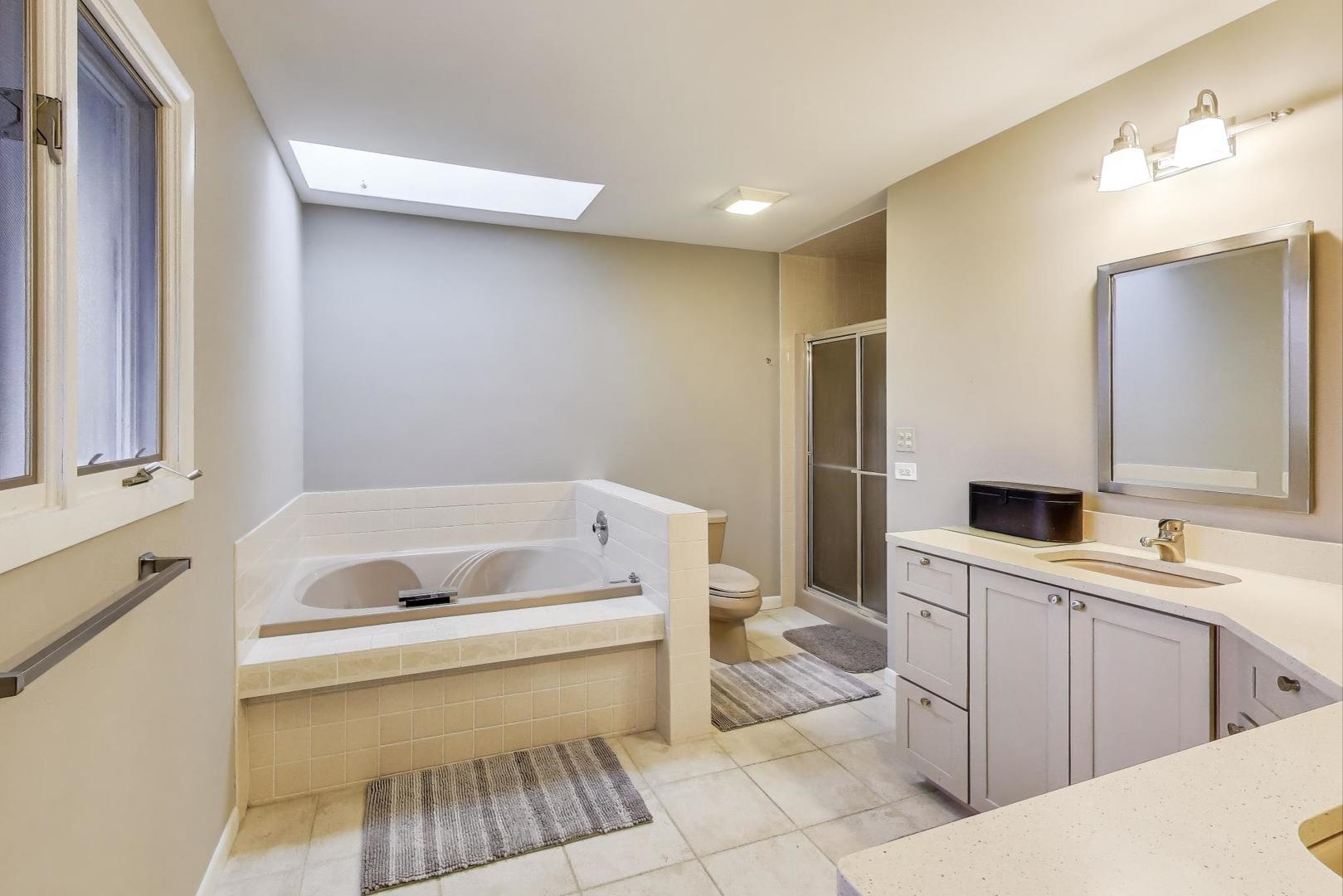 11515 Burr Oak Lane Burr Ridge, IL 60527 - Photo 25 of 73 a bathroom with a sink toilet vanity and tub
