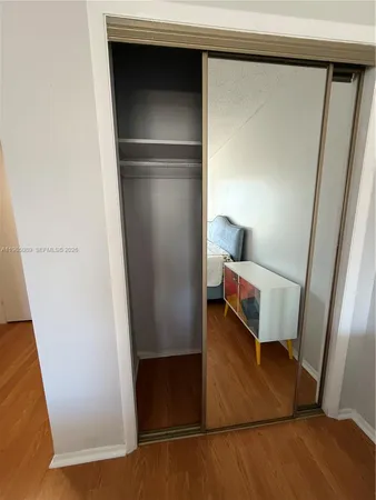 a view of walk in closet with wooden floor