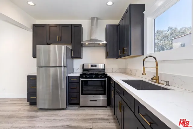 a kitchen with stainless steel appliances granite countertop a refrigerator stove and sink