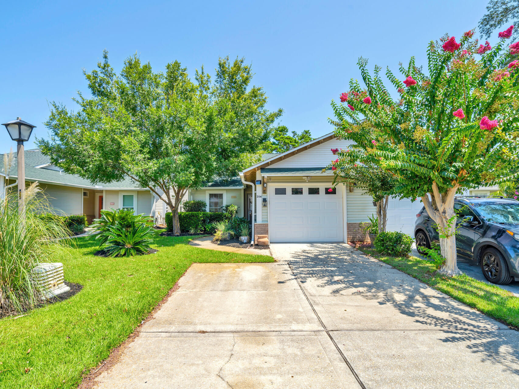 204 Vía Largo, Unit 29B Santa Rosa Beach, FL 32459 - Photo 2 of 40 a front view of a house with a yard and a garden
