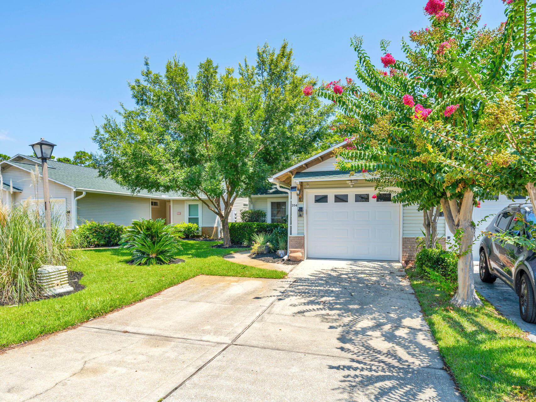 204 Vía Largo, Unit 29B Santa Rosa Beach, FL 32459 - Photo 3 of 40 a front view of a house with a yard and a garage
