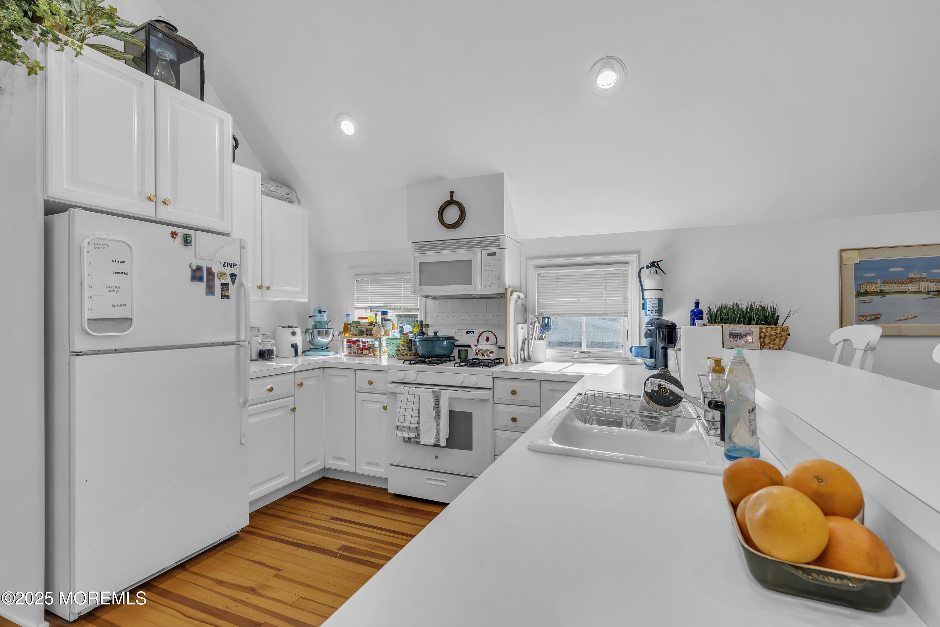 202 Ludlow Avenue Spring Lake, NJ 07762 - Photo 80 of 99 a kitchen with stainless steel appliances granite countertop a sink a stove a refrigerator and white cabinets with wooden floor