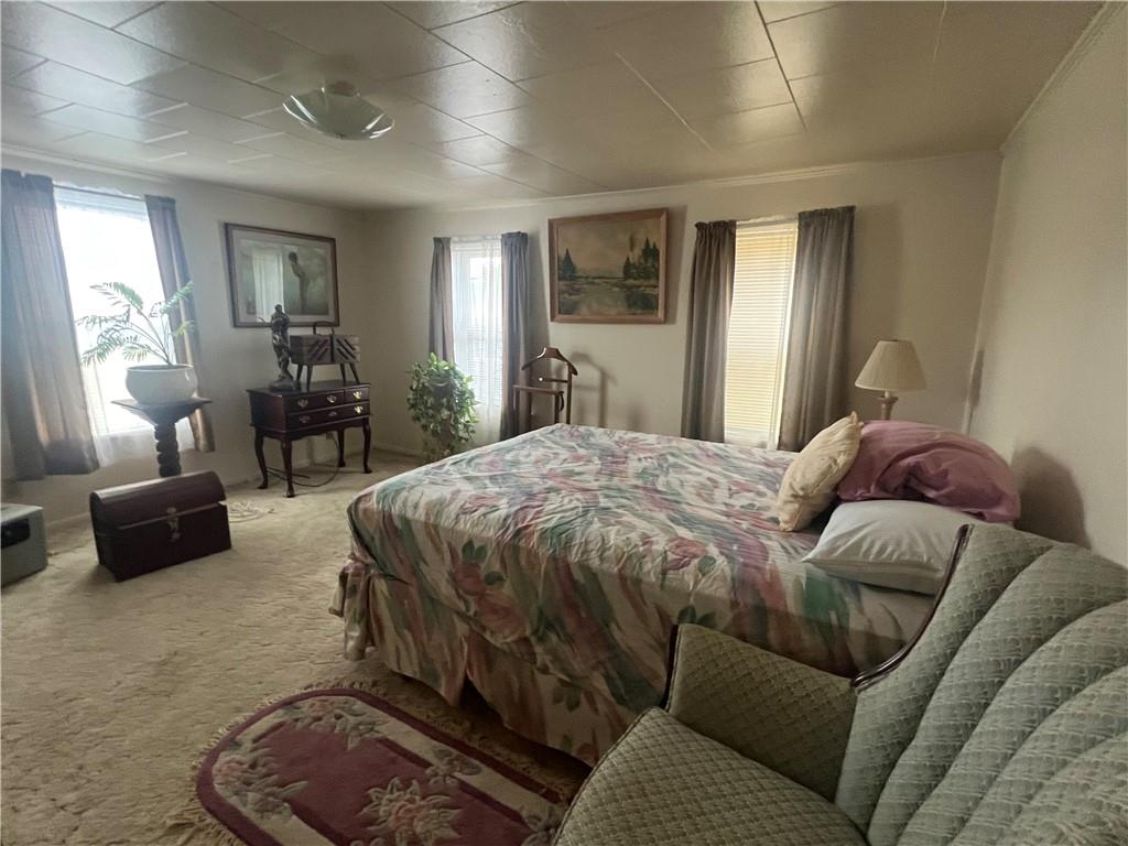 209-211 Old School Road Luxor, PA 15662 - Photo 14 of 27 a spacious bedroom with a bed a couch and large windows