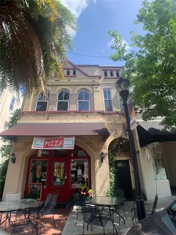 a front view of a house with lots of trees and plants