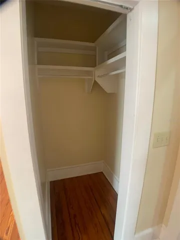 a view of walk in closet with wooden floor