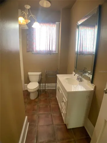 a bathroom with a sink toilet and window