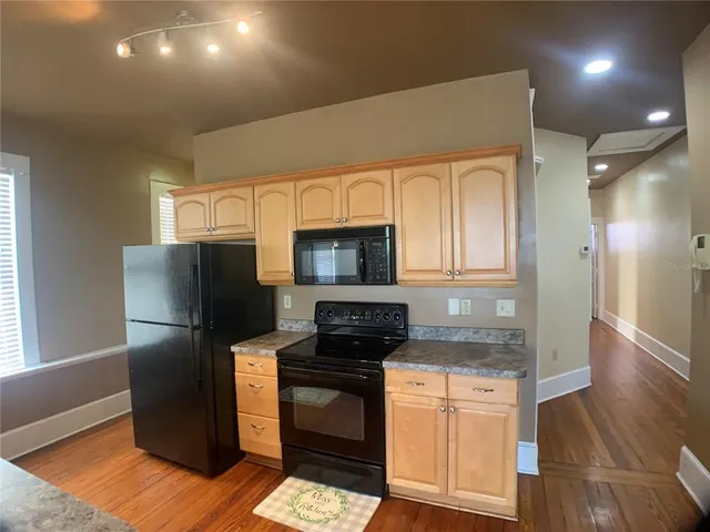 a kitchen with granite countertop a refrigerator stove and sink
