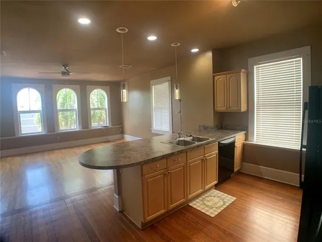 a kitchen with stainless steel appliances granite countertop a sink a stove and a wooden floors