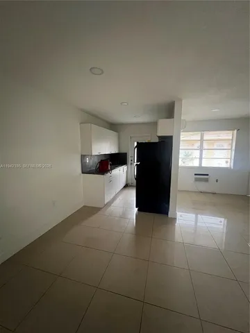 a view of a kitchen with a sink and a refrigerator