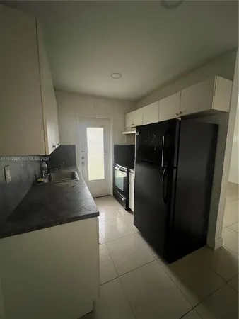 a kitchen with a refrigerator and a sink