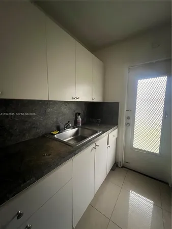 a kitchen with granite countertop white cabinets stainless steel appliances and sink