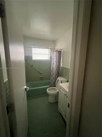 a bathroom with a toilet a sink a shower and mirror