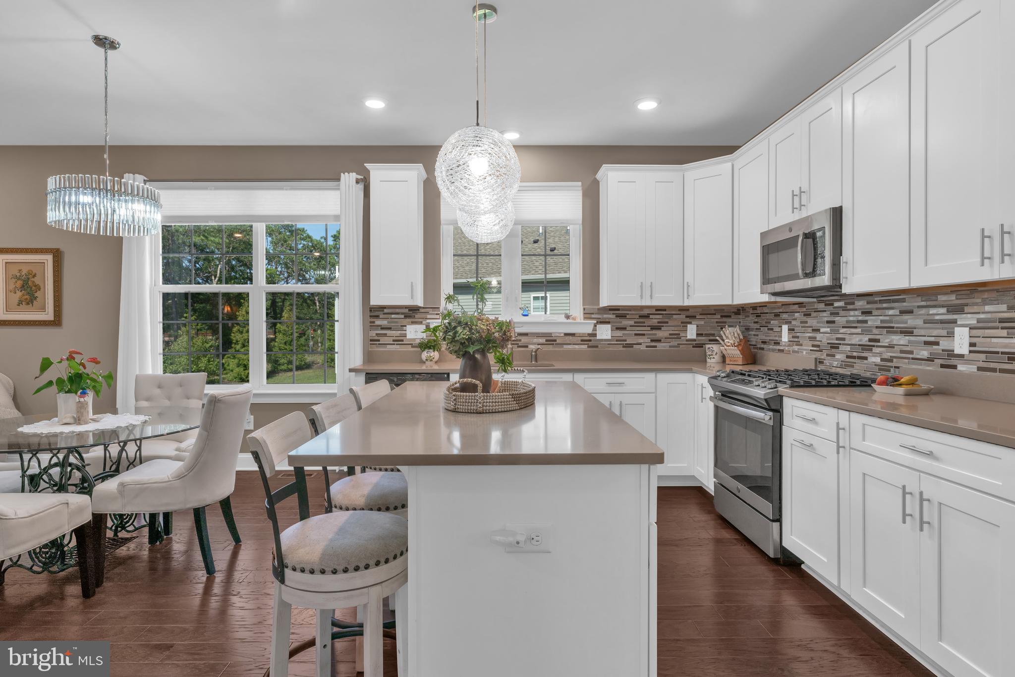 66 Butler Drive Barnegat, NJ 08005 - Photo 7 of 49 a kitchen with stainless steel appliances granite countertop a stove a sink a microwave a dining table and chairs