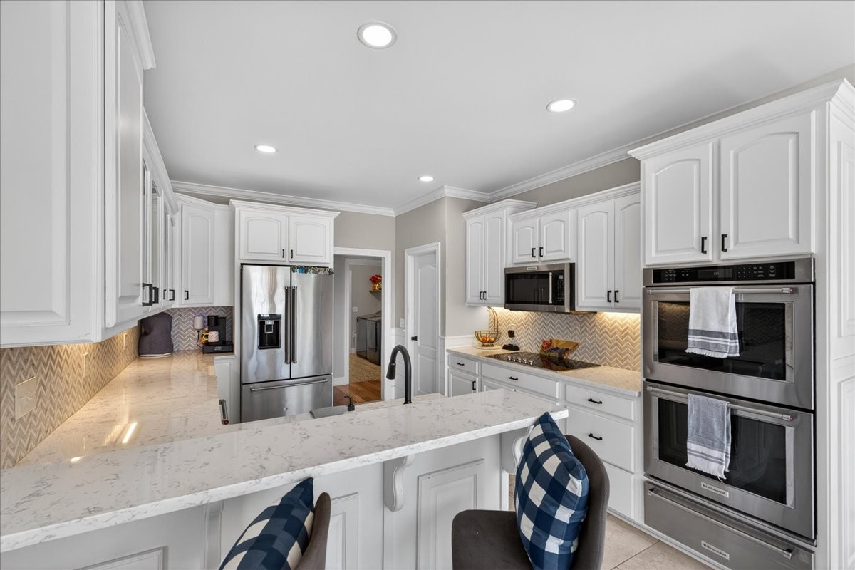 11039 Panther Creek Road Christiana, TN 37037 - Photo 15 of 76 a kitchen with stainless steel appliances a stove a sink a microwave a refrigerator and cabinets