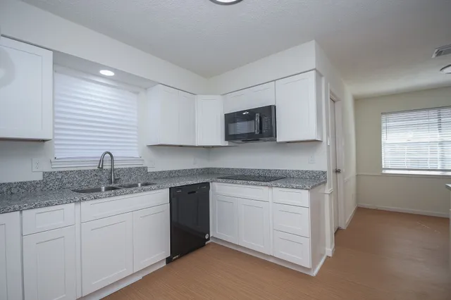a kitchen with stainless steel appliances granite countertop a sink stove and microwave