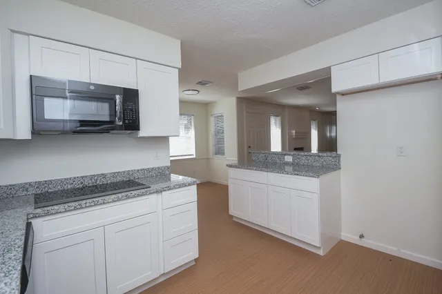 a kitchen with stainless steel appliances granite countertop a stove microwave and sink