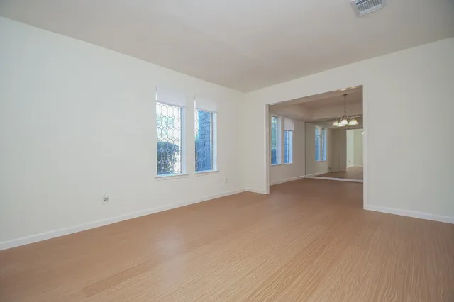 a view of an empty room with window and bathroom