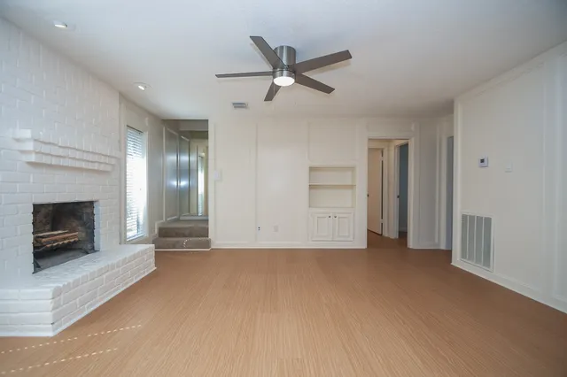 a view of an empty room with a fireplace and a window
