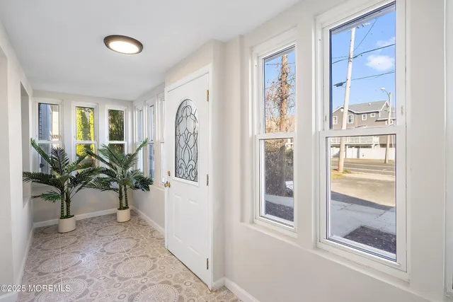 a view of a hallway with wooden floor and windows