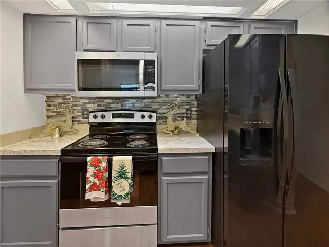 a kitchen with stainless steel appliances granite countertop a stove microwave and refrigerator