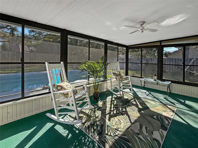 a view of a living room with furniture and floor to ceiling window